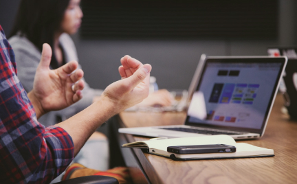 Person in front of laptop talking with hand gestures