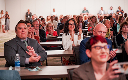 Conference attendees applauding during a panel discussion.