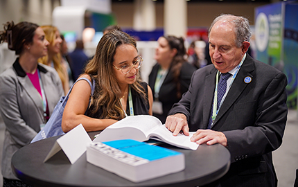 Image of two people discussing a book